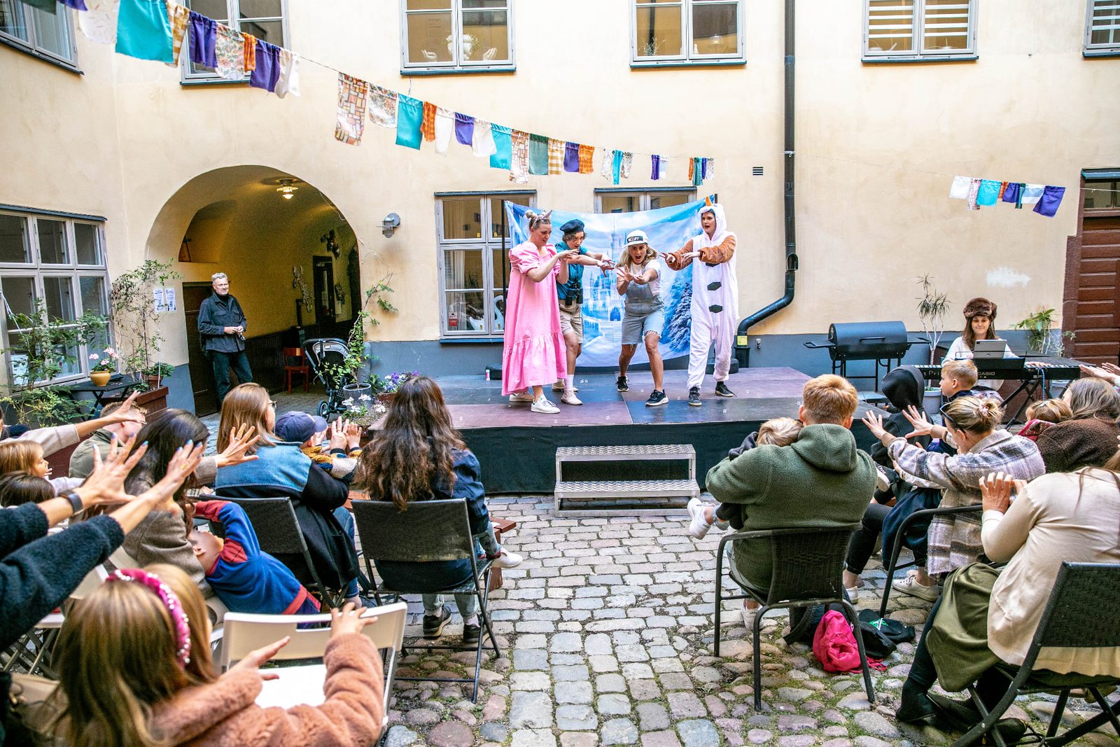 Hela gården sjunger och gör rörelserna tillsammans med ensemblen.